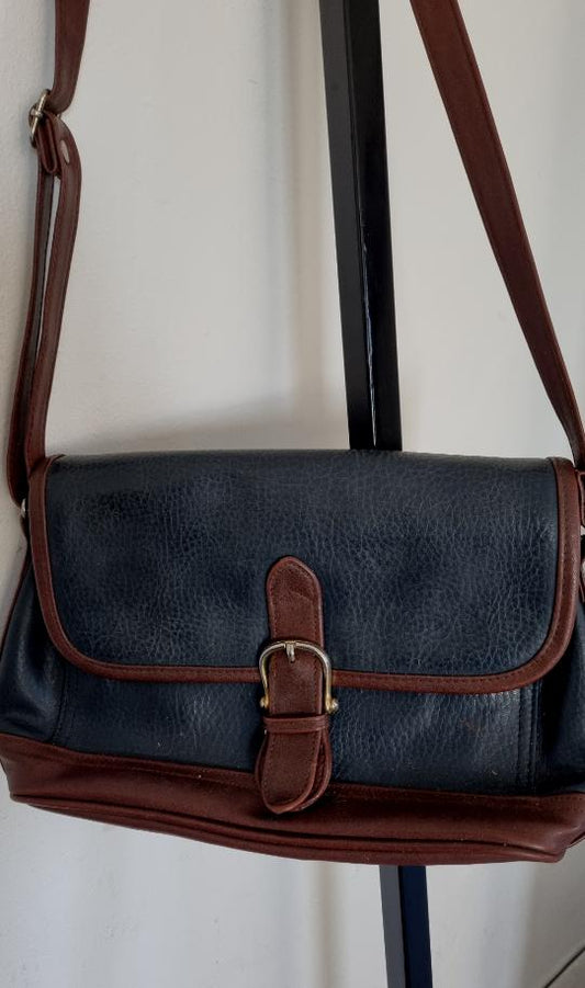 Cartera cuero negra y marrón con hebilla.